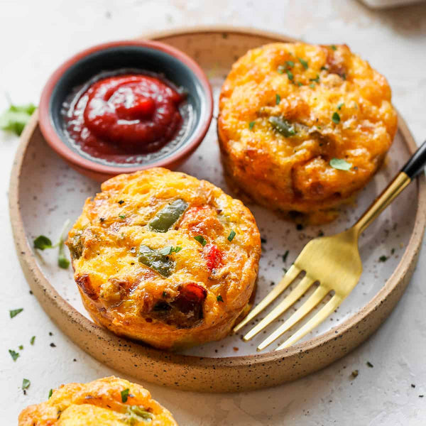 High-Protein Steak Egg Muffins on a plate, featuring succulent steak pieces, eggs, spinach, and peppers, garnished with cheese - Macro Based Diner Healthy Meal Prep